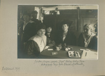 Photographie du réfectoire de la Croix Blanche polonaise (occupé sans doute par des bénévoles) installé dans un wagon à destination de la 1re Division (d'infanterie?) polonaise sur le front lituanien, en octobre (probablement 1920 plutôt que 1919)