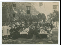 Photographie du «jour de la bénédiction (baptême) du nom d'Hélène Paderewska de la maison des prisonniers de guerre (de la Croix Blanche polonaise) du 67 de la rue Dzielna à Varsovie» – avec légende manuscrite au verso