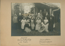 Photographie des employés de la Croix Blanche polonaise devant l'entrée principal de l'entrepôt de Praga, quartier de Varsovie – avec légende manuscrite