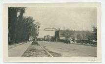 Photographie de la rue centrale «El Camino Real» de Paso Robles, en Californie, en 1921, traversée par la bannière du «Paso Robles Hot Springs Hotel» [Hôtel des sources d'eau chaude], avec à gauche la cloche de la Mission